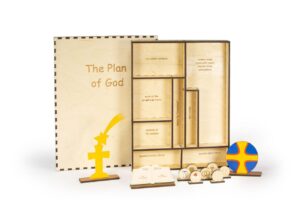 Wooden religious educational set titled "The Plan of God," featuring various labelled compartments, symbols, and figures, including a cross and star, for teaching religious concepts and history.